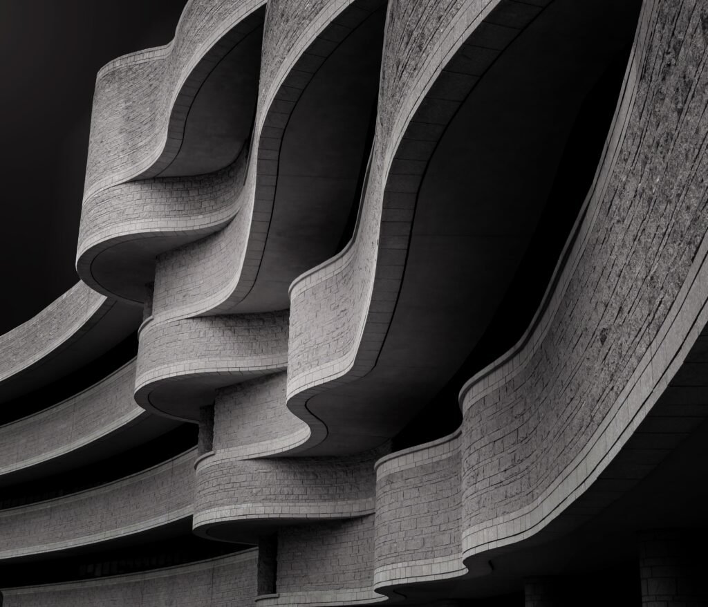 A low angle greyscale of a building with modern brutalist architecture under the sunlight